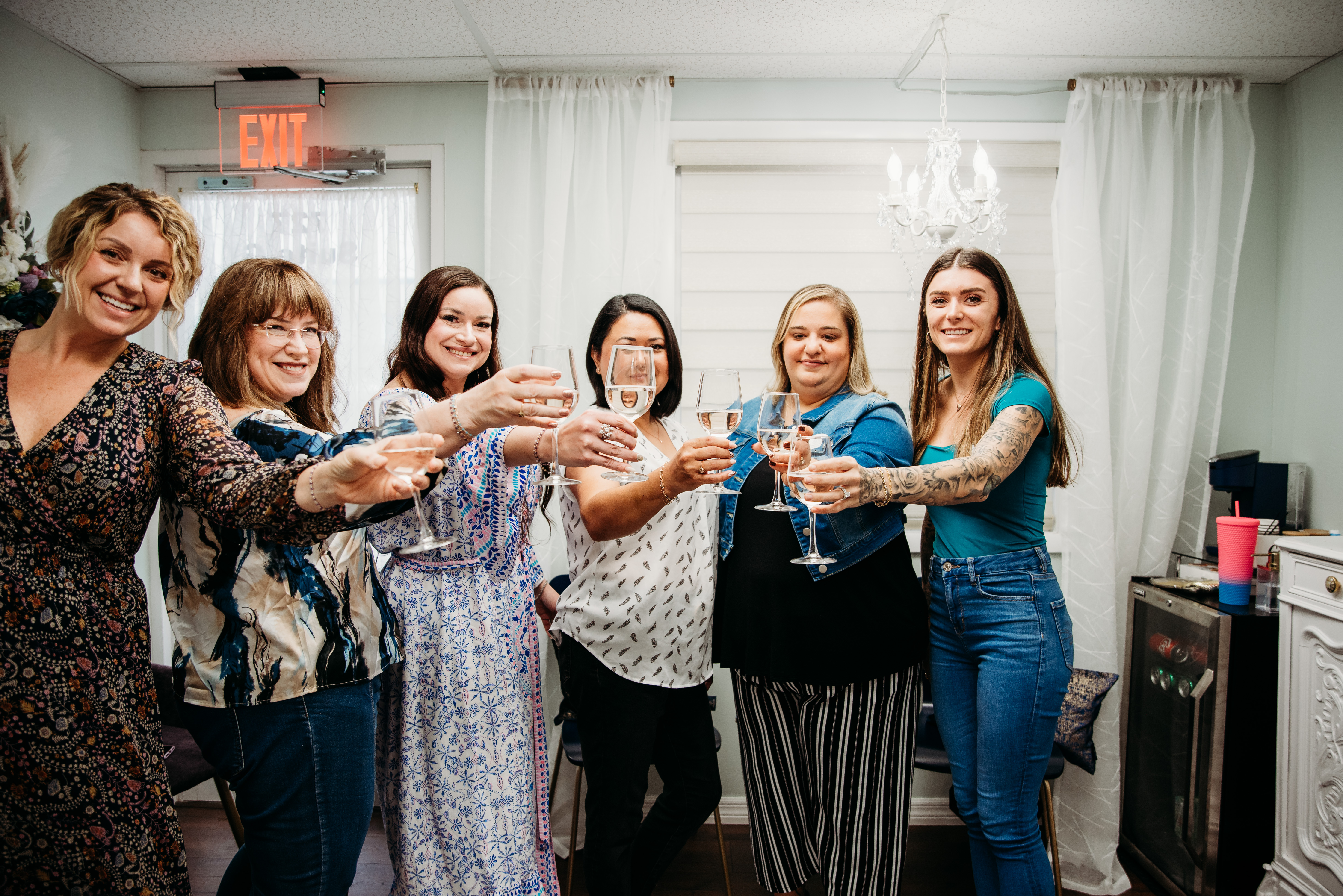Group of friends toasting at a private permanent jewelry party at Bella Vous Beauty