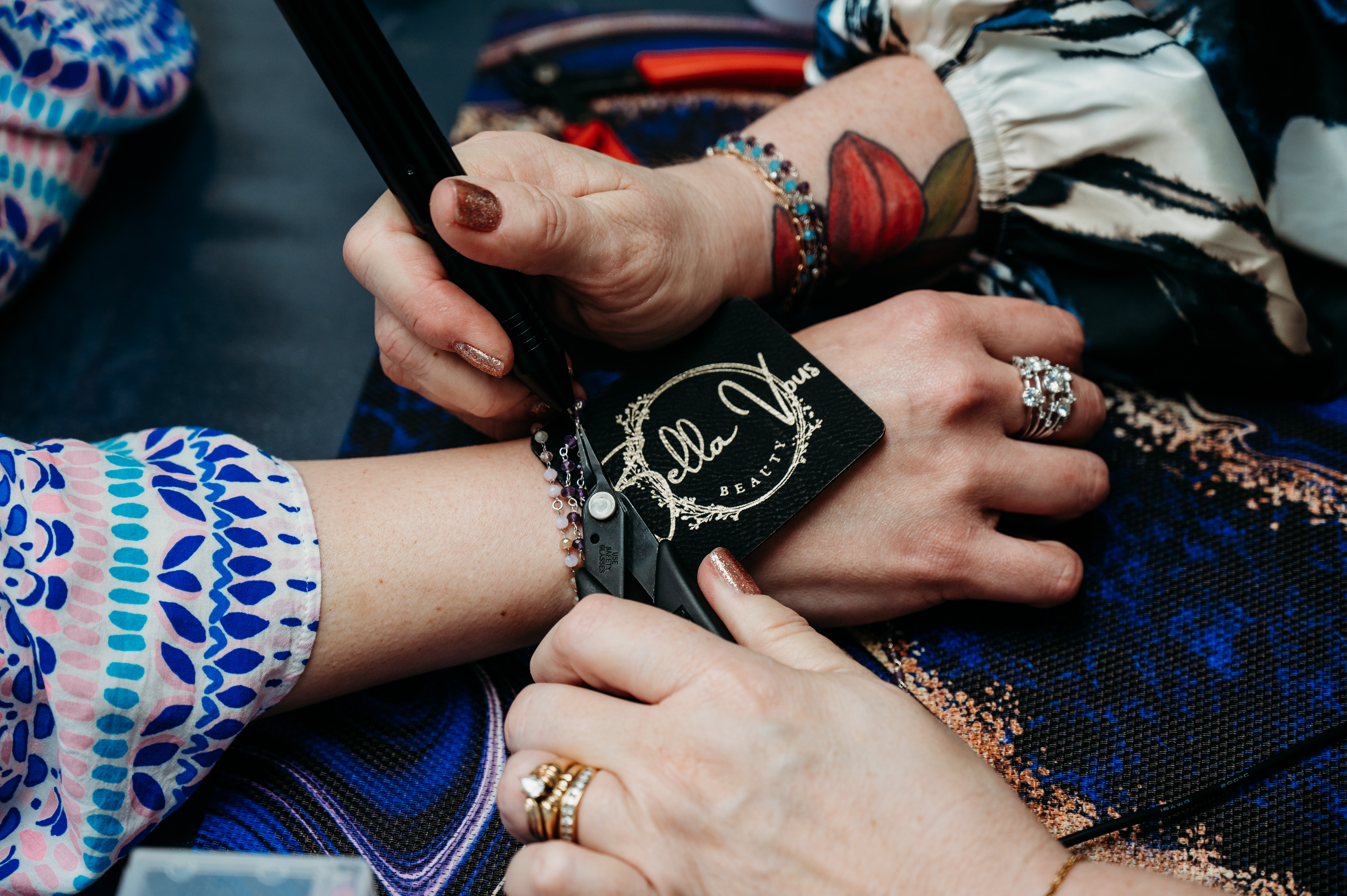 A permanent jewelry chain being measured and welded on a Bella Vous Beauty card